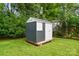New backyard storage shed with white trim and door sitting on a bright green lawn at 204 Craig St, Mount Holly, NC 28120