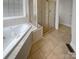 Bathroom featuring a jacuzzi bathtub, tile flooring, and separate glass door shower at 204 W Boyd St, Maiden, NC 28650