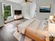 Staged bedroom with hardwood floors, ceiling fan, and natural light from windows overlooking mature trees at 204 W Boyd St, Maiden, NC 28650