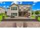 Expansive backyard features a brick patio, tiered deck, and well-maintained landscaping, perfect for outdoor enjoyment at 2289 Pine Valley Dr, Denver, NC 28037