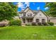 Charming two-story home featuring manicured landscaping, a covered porch, and classic brick accents at 2289 Pine Valley Dr, Denver, NC 28037