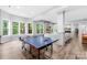 Spacious game room featuring a ping pong table, stone fireplace, and plenty of natural light at 2289 Pine Valley Dr, Denver, NC 28037