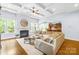 Cozy living room with fireplace, large windows, hardwood floors, and an open layout leading to the kitchen at 2289 Pine Valley Dr, Denver, NC 28037