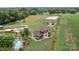 Aerial view of a home with a pool, barns, white horse training ring, and agricultural fields at 2310 Gill Jordan Rd, Chester, SC 29706