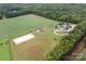 Wide aerial view of an equestrian estate featuring stables, training ring, home, pool, and agricultural fields at 2310 Gill Jordan Rd, Chester, SC 29706