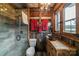 Rustic bathroom with wood paneled walls, glass enclosed shower, vanity with copper sink, and view of wooded area at 2310 Gill Jordan Rd, Chester, SC 29706