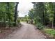 Gravel driveway leading into a property through a wooded area and a gated fence at 2310 Gill Jordan Rd, Chester, SC 29706
