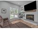 Cozy living room featuring a brick fireplace with floating shelves, a comfortable couch, and natural light from the window at 2577 Bonnybrook Cir, Rock Hill, SC 29732