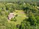 Aerial shot of a home on a verdant lot with a tranquil pond and a long private driveway at 2818 Neill Rd, Lancaster, SC 29720