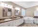 Bright bathroom featuring double sinks, stained glass window, and tub at 2818 Neill Rd, Lancaster, SC 29720