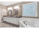 Bright bathroom featuring double sinks, stained glass window, and corner tub at 2818 Neill Rd, Lancaster, SC 29720