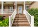 Brick steps lead to a covered porch with white railing and storm door, creating a welcoming entrance at 2818 Neill Rd, Lancaster, SC 29720