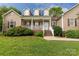 Inviting front porch with white railing and brick base, enhanced by lush landscaping and a grassy yard at 2818 Neill Rd, Lancaster, SC 29720