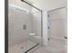 Beautiful shower in a bathroom featuring a glass door and grey patterned tile at 3128 Spring Iris Dr, Denver, NC 28037
