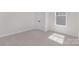 Clean, bright bedroom featuring plush carpet, natural light, and minimalist decor at 3128 Spring Iris Dr, Denver, NC 28037