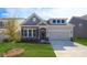 Charming home features a stone facade, gray siding, a manicured lawn, and an attached two-car garage at 3128 Spring Iris Dr, Denver, NC 28037