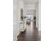 Hallway features hardwood floors, white wainscoting, and access to the living room with large windows at 3128 Spring Iris Dr, Denver, NC 28037