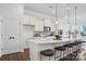 A spacious modern kitchen with white cabinets, stainless steel appliances, and a large island with barstool seating at 3128 Spring Iris Dr, Denver, NC 28037