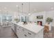 Modern kitchen with stainless steel appliances, a kitchen island, and view to living room with fireplace at 3128 Spring Iris Dr, Denver, NC 28037