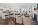 A modern living room and kitchen area with dark floors, white walls, and a cozy fireplace at 3128 Spring Iris Dr, Denver, NC 28037