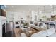 Open-concept living room boasts ample seating and elegant decor, flowing seamlessly into the dining area and kitchen at 3128 Spring Iris Dr, Denver, NC 28037