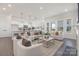 Bright, open living room featuring stylish furnishings, modern lighting, and large windows for plenty of natural light at 3128 Spring Iris Dr, Denver, NC 28037