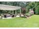 Inviting backyard with covered outdoor kitchen and seating area and mature trees at 3204 Mcpherson St, Waxhaw, NC 28173