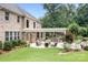Brick home with a spacious backyard featuring a covered outdoor kitchen and seating area and mature trees at 3204 Mcpherson St, Waxhaw, NC 28173