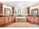 Bathroom featuring dual sinks, granite countertops, wood cabinets, and a soaking tub at 3204 Mcpherson St, Waxhaw, NC 28173