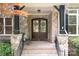 Charming covered front entrance showcasing double doors with wreaths and stone accents at 3204 Mcpherson St, Waxhaw, NC 28173