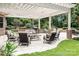 Outdoor seating area with white pergola, seating, landscaping, and brick fireplace at 3204 Mcpherson St, Waxhaw, NC 28173