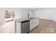 Kitchen island featuring granite countertops, a stainless steel dishwasher, white cabinets, and a sink at 3323 Burberry Dr, Gastonia, NC 28052