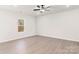 Bright main bedroom with vinyl flooring, neutral walls, a ceiling fan, and a large window at 3323 Burberry Dr, Gastonia, NC 28052