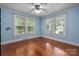 Cozy bedroom featuring light blue walls, hardwood floors, and multiple bright windows at 34 Admiral Sw Ave, Concord, NC 28027
