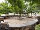 Paved community gathering space with stone benches, tables, and mature shade trees at 403 Park Meadows Dr, Matthews, NC 28104