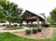Community gathering space with wooden pergola, built-in benches, and surrounding landscaping at 403 Park Meadows Dr, Matthews, NC 28104