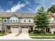 Charming townhome featuring stone accents, a driveway, and manicured landscaping under a partly cloudy sky at 403 Park Meadows Dr, Matthews, NC 28104