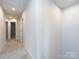 Well-lit hallway with neutral carpet and paint, leading to various rooms in the home at 403 Park Meadows Dr, Matthews, NC 28104