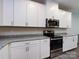 Kitchen showcasing white cabinets, stainless steel oven and microwave, and gray countertops at 403 Park Meadows Dr, Matthews, NC 28104