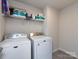 A laundry room featuring a full-size washer and dryer, tile floor and shelves at 403 Park Meadows Dr, Matthews, NC 28104