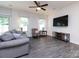 Cozy living room features a ceiling fan, comfortable furniture, and a mounted television for entertainment at 403 Park Meadows Dr, Matthews, NC 28104