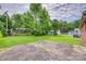 The large backyard has lush green lawn, mature trees and concrete tiles at 409 Scaleybark Rd, Charlotte, NC 28209