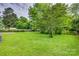 Large backyard with lush green lawn and mature trees at 409 Scaleybark Rd, Charlotte, NC 28209