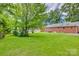 Expansive backyard featuring lush lawn and mature trees, surrounding the home at 409 Scaleybark Rd, Charlotte, NC 28209