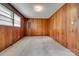 Bedroom featuring wood paneling, neutral carpet, window, and overhead lighting at 409 Scaleybark Rd, Charlotte, NC 28209
