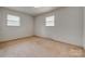 Bedroom with neutral walls, carpet, and two windows offering ample natural light at 409 Scaleybark Rd, Charlotte, NC 28209