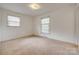 Bedroom featuring neutral walls, carpet, and two windows for plenty of natural light at 409 Scaleybark Rd, Charlotte, NC 28209