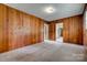 View of bedroom showcasing wood paneling, carpet, and access to other rooms in the home at 409 Scaleybark Rd, Charlotte, NC 28209