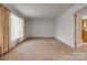 Spacious living room with plush carpet and bright natural light from the large window at 409 Scaleybark Rd, Charlotte, NC 28209
