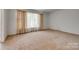 Cozy living room with wall to wall carpet, large window with curtains and neutral walls at 409 Scaleybark Rd, Charlotte, NC 28209